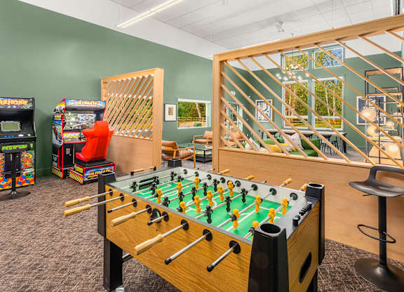 A foosball table is in the middle of a room with arcade games.