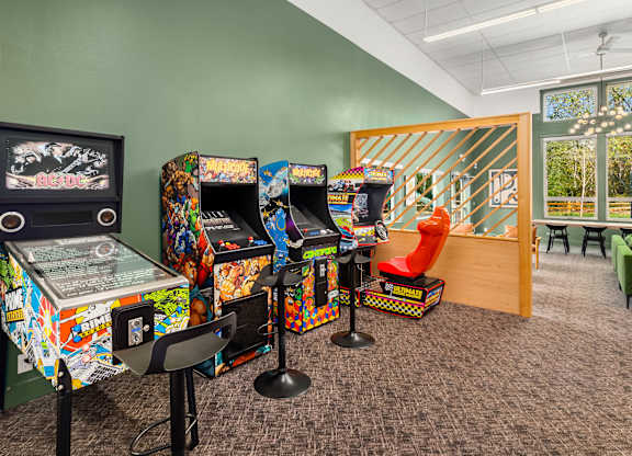 A room with arcade machines and chairs.
