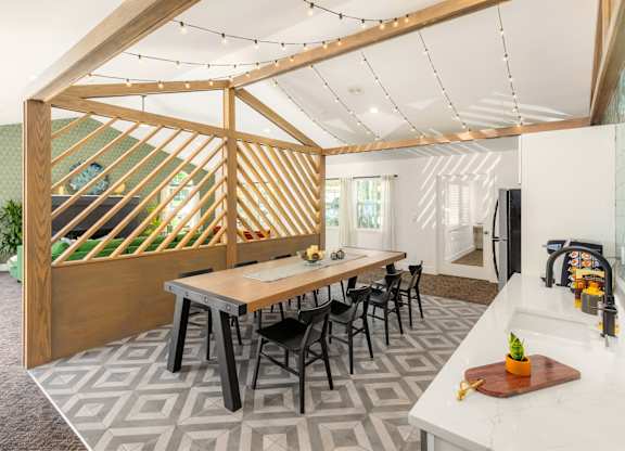 A kitchen with a dining table and chairs.
