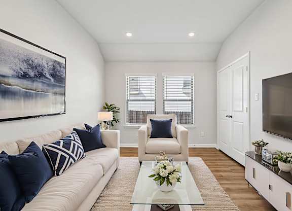 A living room with a couch, chairs, and a painting on the wall.