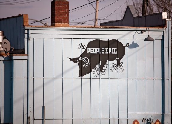 a sign on the side of a building with a cow on it
