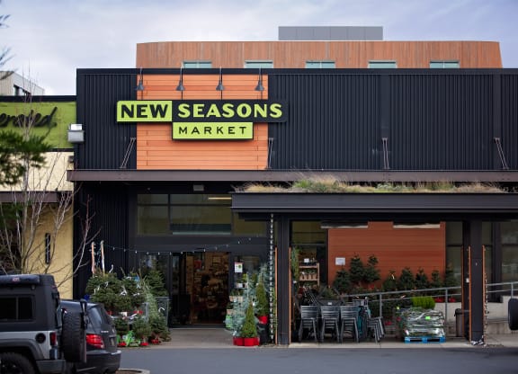 the front of new seasons market with cars parked outside