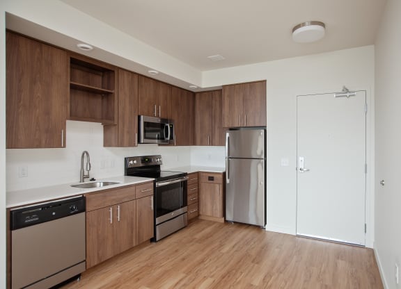 an empty kitchen with wooden cabinets and stainless steel appliances