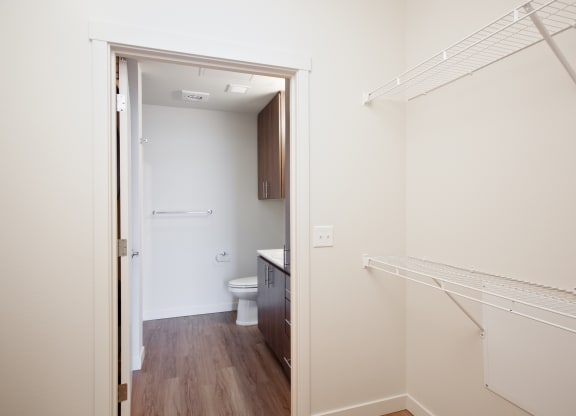 a bedroom with a closet and a bathroom with a toilet