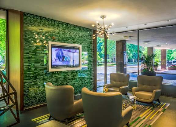 A lounge area with chairs and tv
