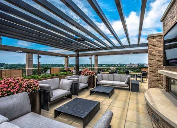 A patio with grey couches and a black coffee table.