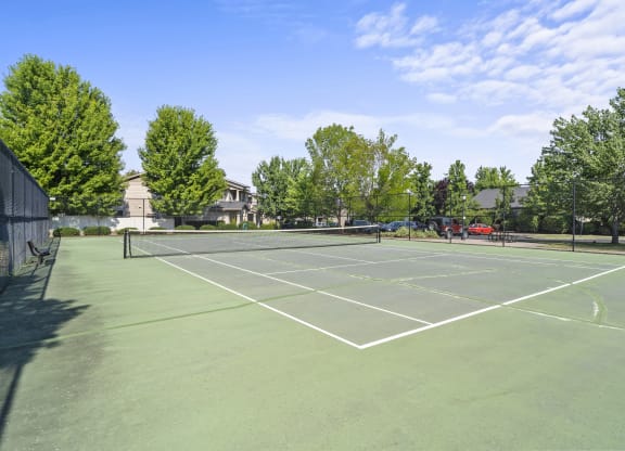 a tennis court at the whispering winds apartments in pearland, tx