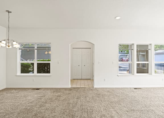 a living room with white walls and a carpeted floor