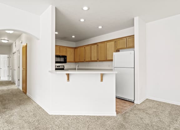 a kitchen with white walls and brown cabinets