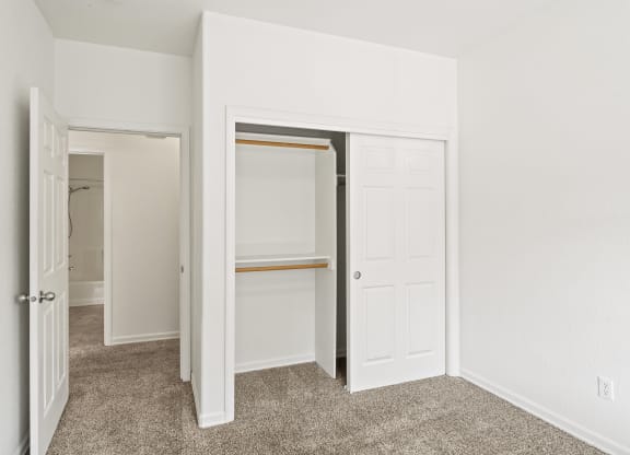 a bedroom with white walls and a carpeted floor