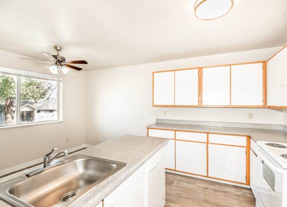 A kitchen with a white stove and a window.