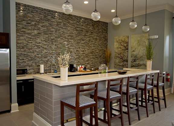A kitchen with a bar area and chairs.