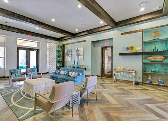A living room with a blue couch and a wooden floor.