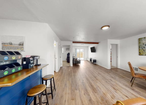 the living room and dining room of a house with wood flooring and a bar