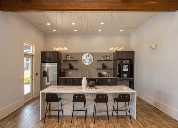 a kitchen with a large island with four chairs around it