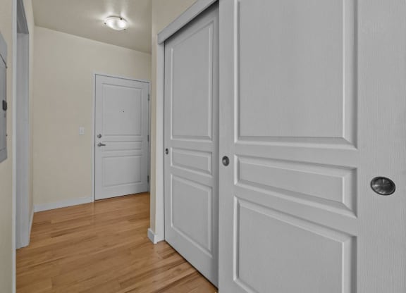 Bedroom with double closet and wood-style flooring at Collins Circle apartments in the Goose Hollow district in Portland, Oregon.