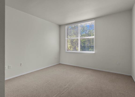 Bedroom with large windows and white walls at Collins Circle apartments in the Goose Hollow district in Portland, Oregon.