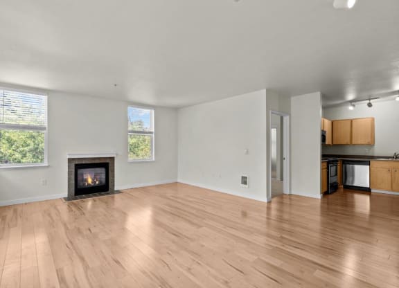 Living room with windows, fireplace, and wood-style flooring at Collins Circle apartments in the Goose Hollow district in Portland, Oregon.