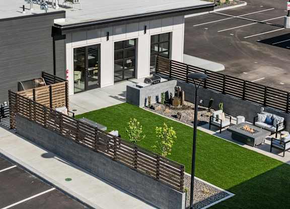 A modern building with a wooden fence and a small garden in front.