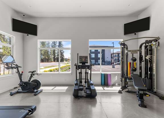 A spacious home gym with a variety of equipment including a treadmill, stationary bike, and weight machines.