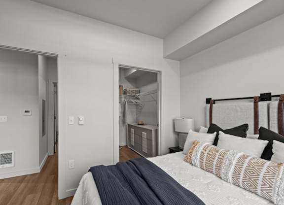 A bedroom with a bed, pillows, and a nightstand.