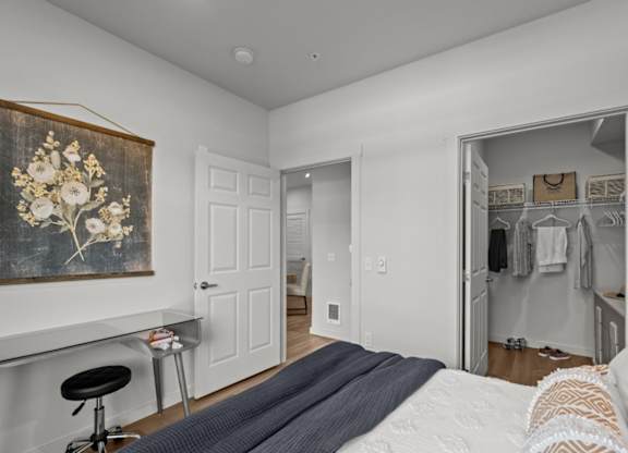 A bedroom with a large bed and a painting on the wall.