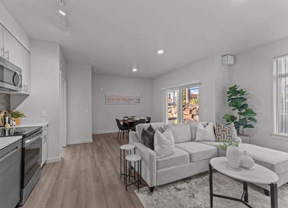 A modern kitchen with a dining area and a living room.