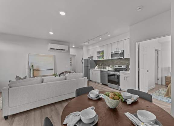 A modern kitchen and living room with a dining table set for a meal.