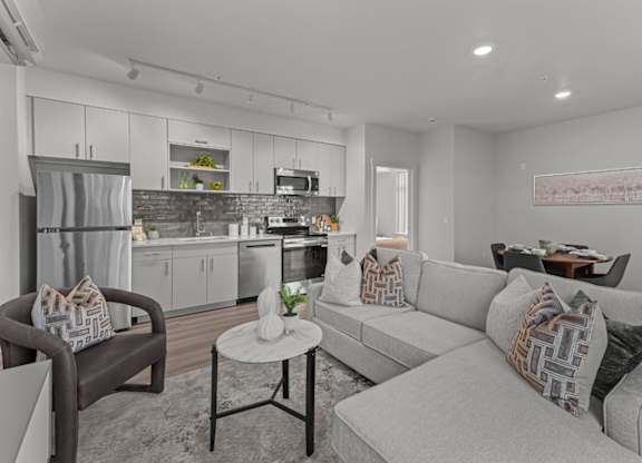 A modern living room with a grey couch and a brown chair.