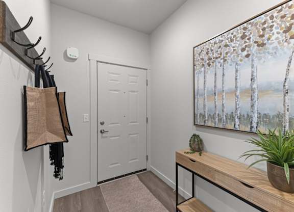 A hallway with a painting of birch trees on the wall.