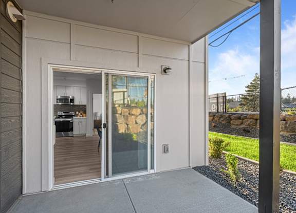 A modern house with a glass door leading to a kitchen.