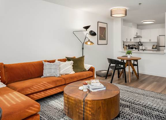 A living room with an orange couch and a coffee table.