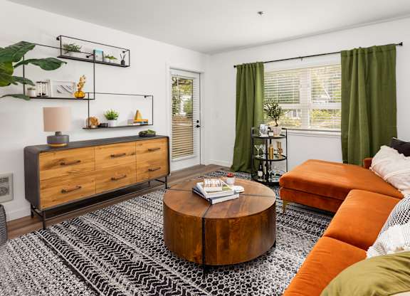 A living room with a brown coffee table and an orange sofa.