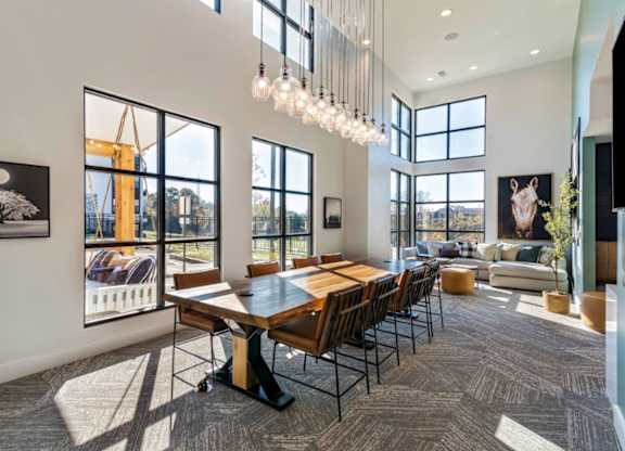 A modern dining room with a large table and chairs.