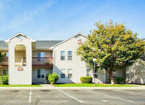 A row of townhouses with a parking lot in front.