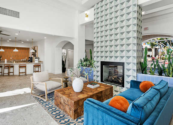 A living room with a blue couch and a fireplace.
