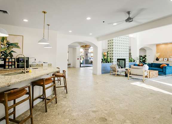 A kitchen with a bar area and a living room area.