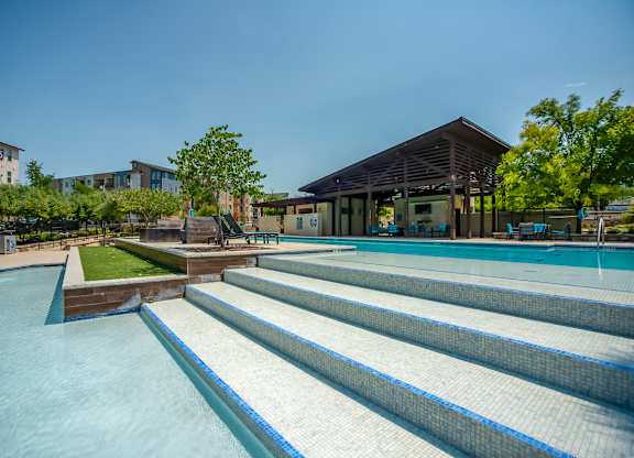 A swimming pool with steps leading down to the water. at Discovery at The Realm, Texas