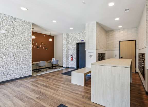 A reception area with a white reception desk and a patterned wallpaper.