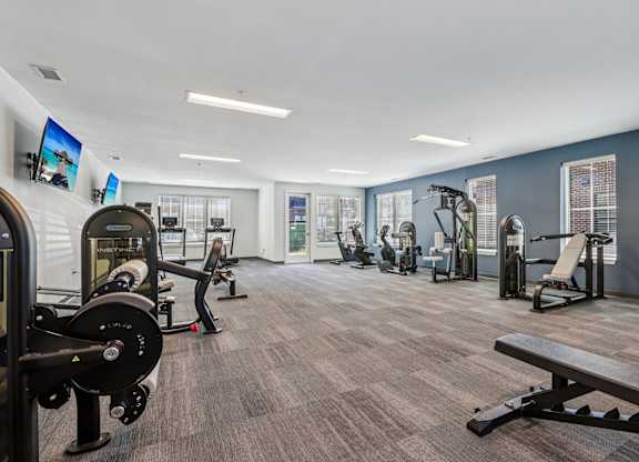 A gym with a variety of equipment including weights and machines.