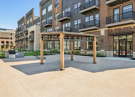 A large open courtyard with a wooden pergola in the middle.
