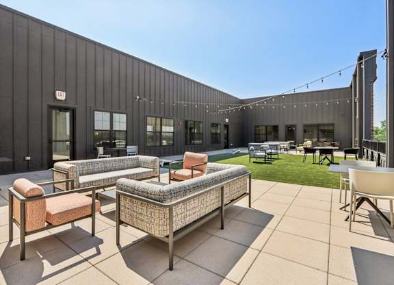 A modern outdoor seating area with a black building in the background.