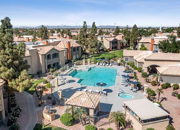 A large swimming pool surrounded by houses and trees.