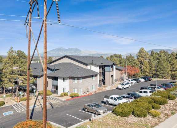 A parking lot with cars and a building in the background.