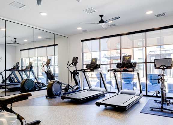 A gym with treadmills, exercise bikes, and elliptical machines.