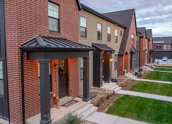 A row of houses with a red brick house in the front.