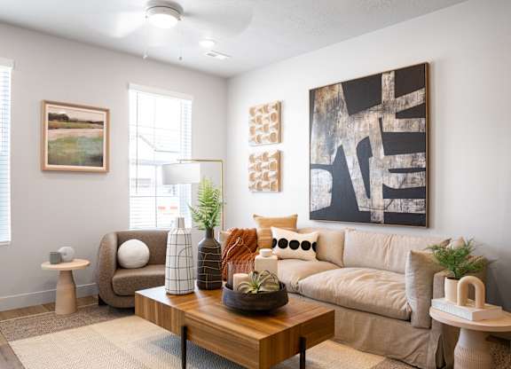 A living room with a couch, a coffee table, and a painting on the wall.