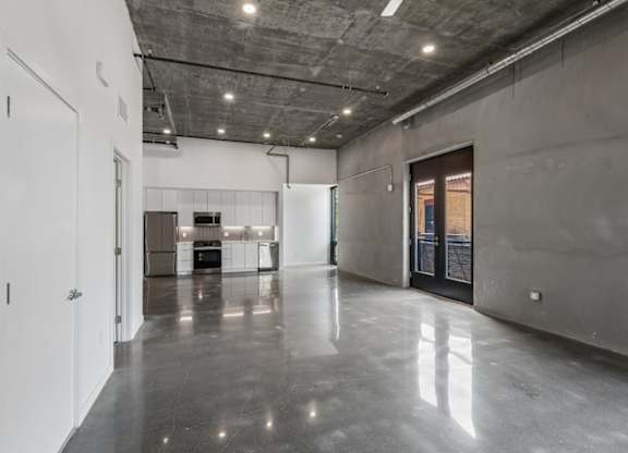 A large, empty room with a concrete floor and walls.