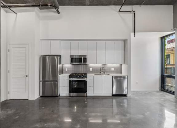 A modern kitchen with stainless steel appliances and white cabinets.