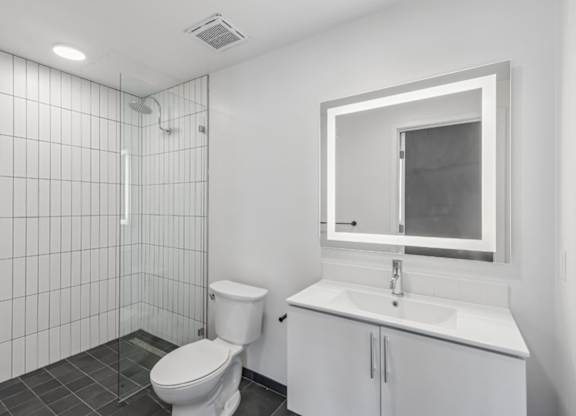 A white toilet sits next to a white sink in a small bathroom.